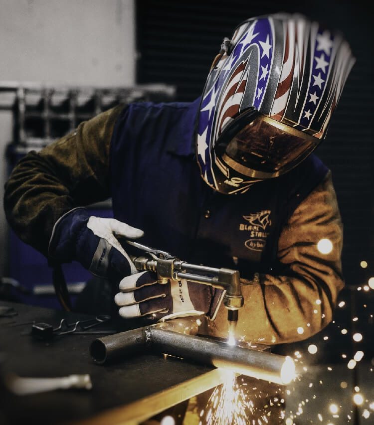 Factory worker using a torch for welding